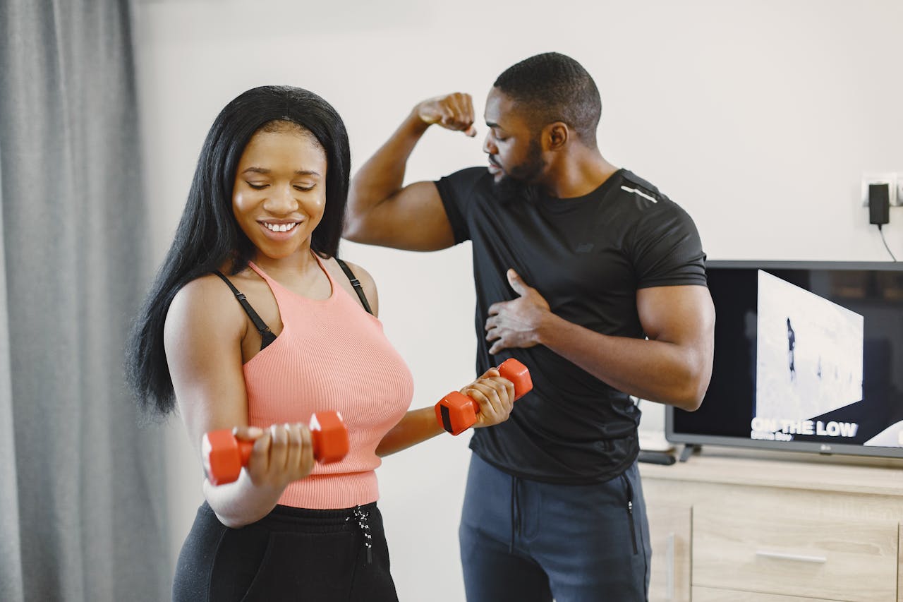 Happy couple exercising at home with dumbbells, promoting a healthy lifestyle.